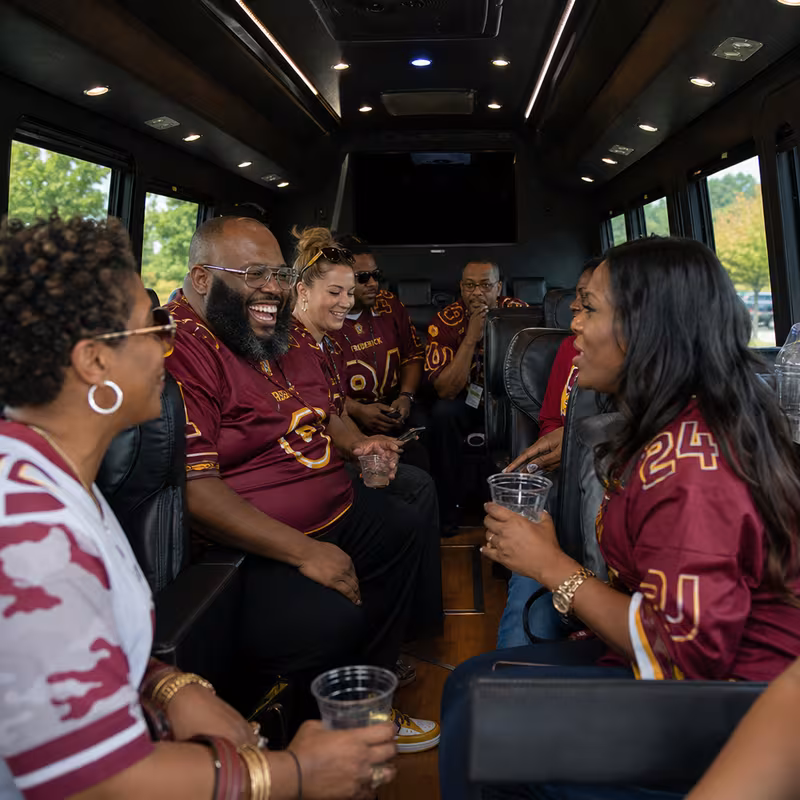 Group boarding a white charter bus for Sporting Event Transportation transportation in Frederick