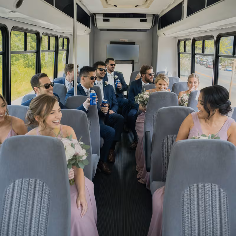 Group boarding a white charter bus for Wedding Transportation transportation in Frederick